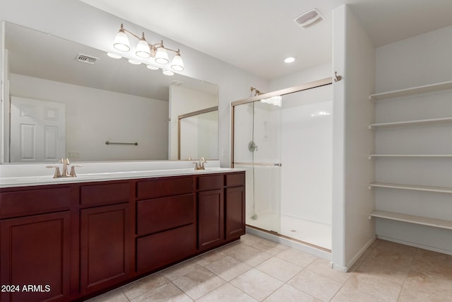 full bath with a stall shower, double vanity, and tile patterned flooring