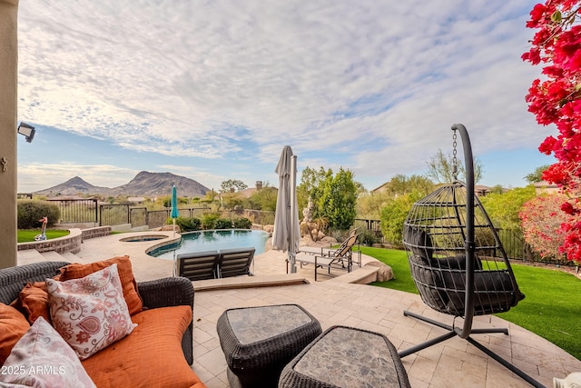 view of patio / terrace with a pool with hot tub and a mountain view