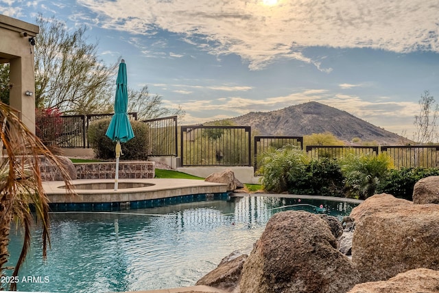 view of swimming pool with a hot tub and a mountain view