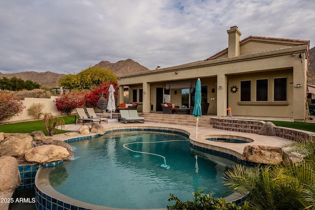 view of swimming pool with a mountain view, an in ground hot tub, and a patio