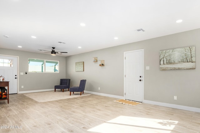 living area featuring light hardwood / wood-style floors and ceiling fan