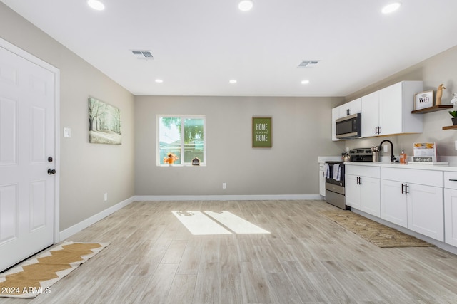 kitchen featuring white cabinets, stainless steel appliances, and light hardwood / wood-style floors