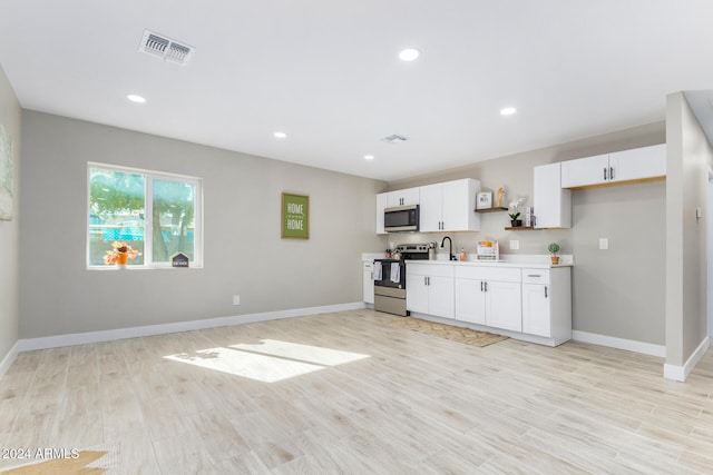 kitchen featuring white cabinetry, appliances with stainless steel finishes, sink, and light wood-type flooring