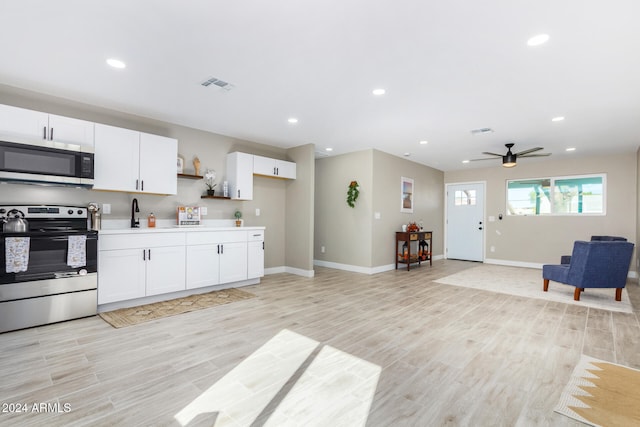 kitchen with white cabinets, ceiling fan, light wood-type flooring, and appliances with stainless steel finishes