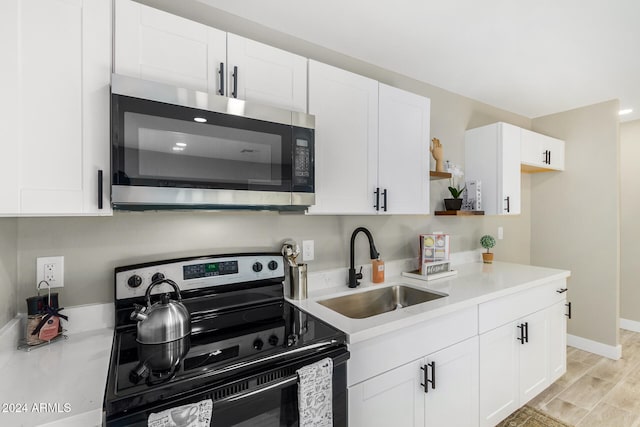 kitchen featuring white cabinetry, appliances with stainless steel finishes, sink, and light hardwood / wood-style floors