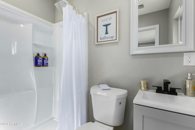 bathroom featuring curtained shower, vanity, and toilet