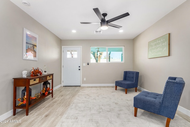 sitting room with light wood-type flooring and ceiling fan