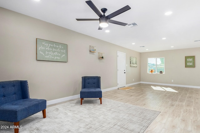 sitting room with ceiling fan and light wood-type flooring