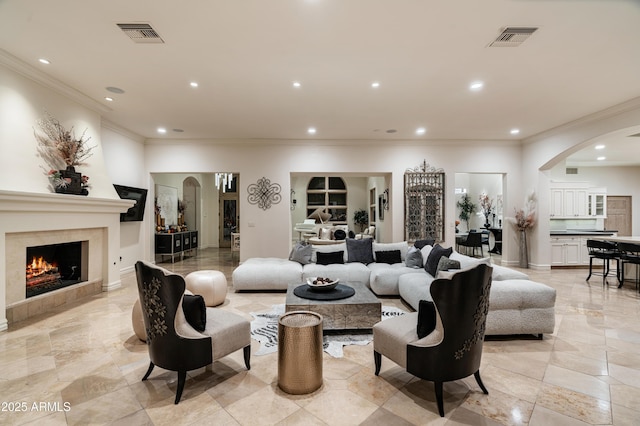 living room with crown molding and a tiled fireplace