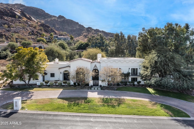 mediterranean / spanish-style house featuring a mountain view and a front yard