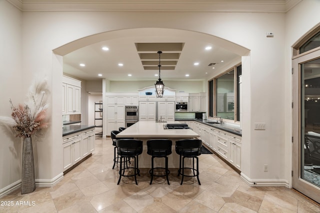 kitchen featuring a center island, white cabinets, a kitchen breakfast bar, sink, and stainless steel appliances