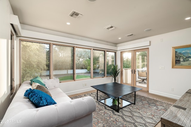 living room with french doors, a healthy amount of sunlight, and wood-type flooring