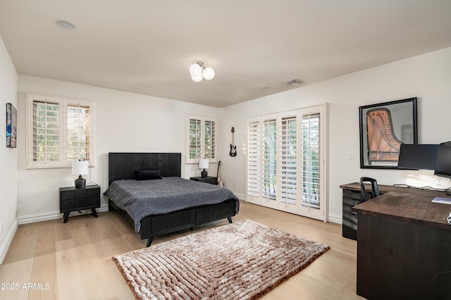 bedroom with access to exterior and light hardwood / wood-style flooring