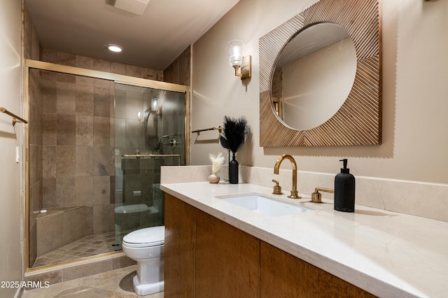 bathroom featuring vanity, a shower with shower door, and toilet