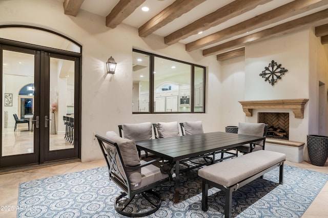 dining space featuring beam ceiling, light tile patterned flooring, and french doors