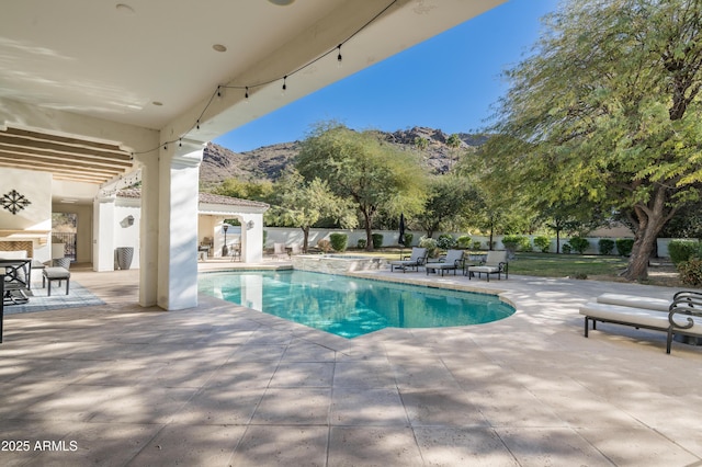 view of swimming pool with a mountain view, a patio, and a hot tub