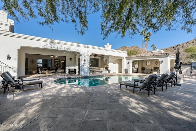 view of swimming pool with a mountain view and a patio