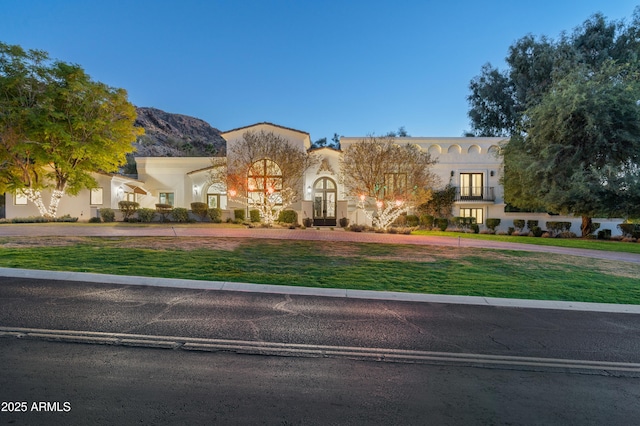 mediterranean / spanish home with a mountain view and a front yard