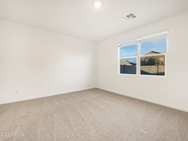 carpeted spare room with visible vents and baseboards