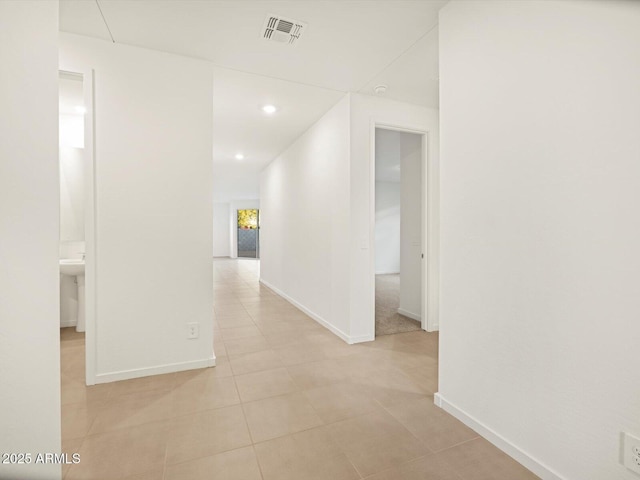 corridor featuring recessed lighting, baseboards, visible vents, and light tile patterned flooring