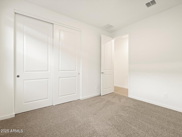 unfurnished bedroom with carpet floors, a closet, visible vents, and baseboards