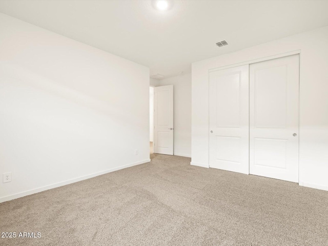 unfurnished bedroom with baseboards, a closet, visible vents, and carpet flooring