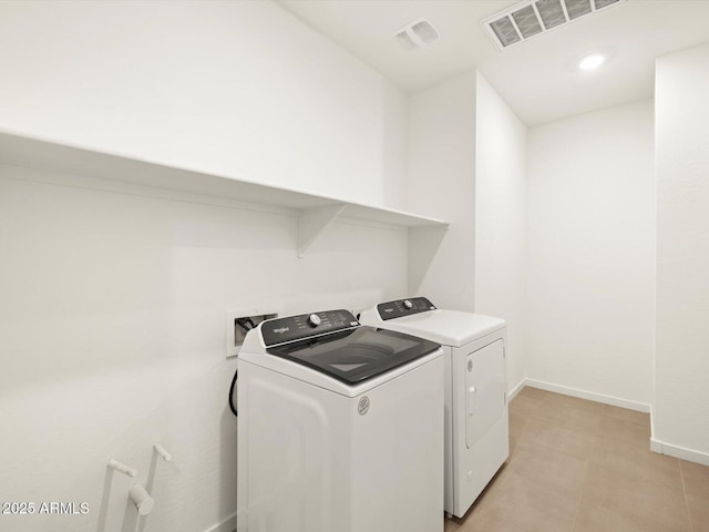 laundry area with baseboards, laundry area, visible vents, and washer and dryer