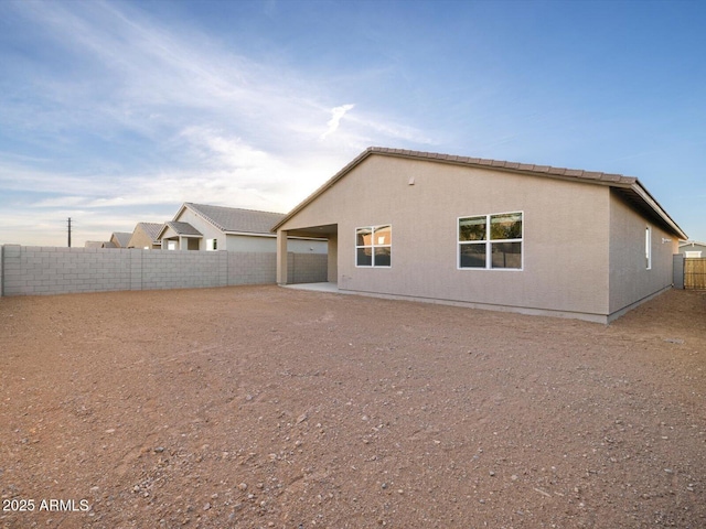 back of property featuring a fenced backyard and stucco siding