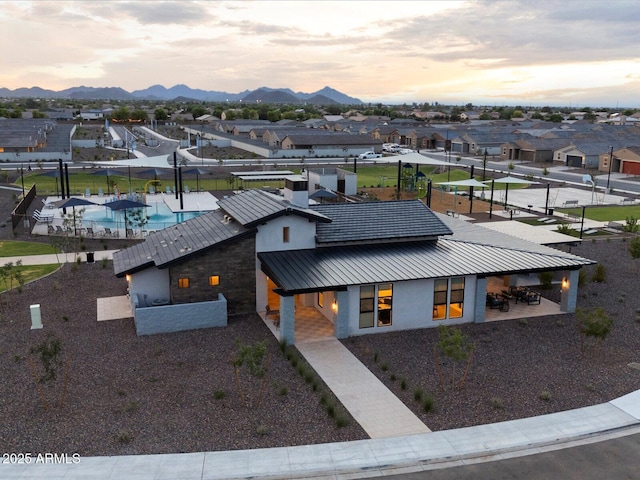 aerial view at dusk featuring a mountain view and a residential view