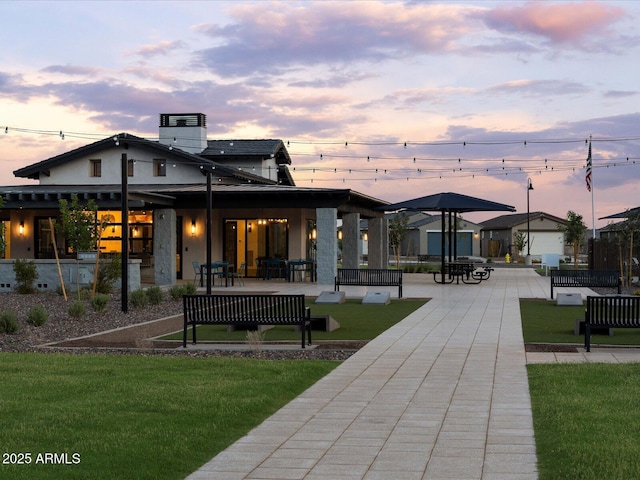 back of house with a patio area, a chimney, and a lawn