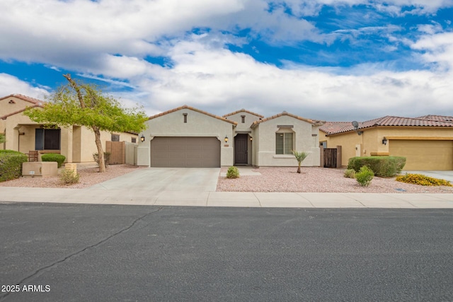 mediterranean / spanish-style house with a tiled roof, stucco siding, an attached garage, and driveway