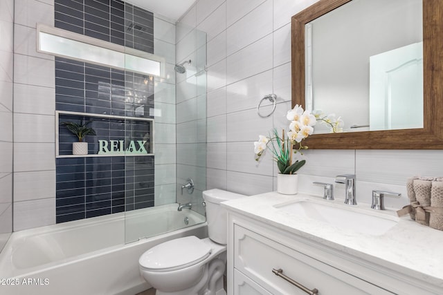 bathroom with shower / bathing tub combination, toilet, tile walls, and vanity