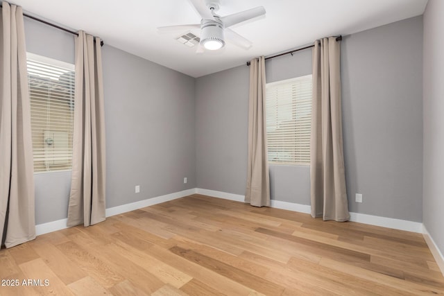 empty room featuring baseboards, a ceiling fan, and light wood finished floors