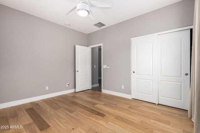 unfurnished bedroom featuring visible vents, baseboards, a closet, and light wood-style flooring