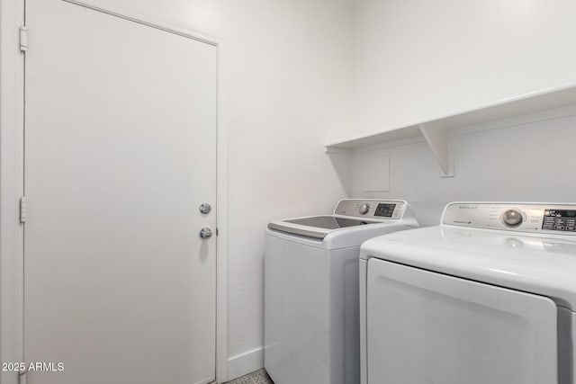 clothes washing area with washing machine and dryer and laundry area