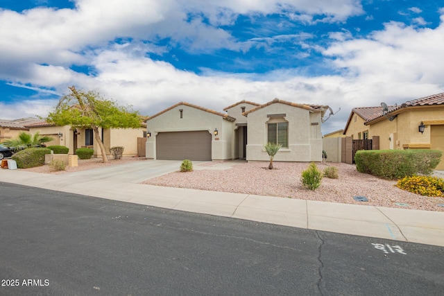 mediterranean / spanish-style home with stucco siding, driveway, a gate, fence, and a tiled roof