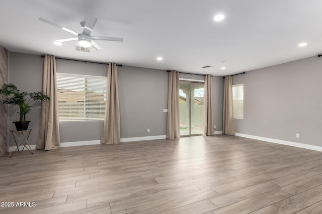 empty room with visible vents, light wood-style flooring, and plenty of natural light