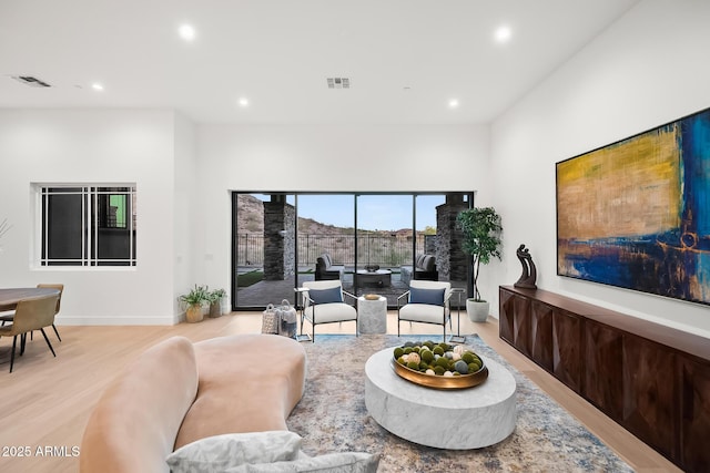 living area with recessed lighting, visible vents, and light wood-type flooring