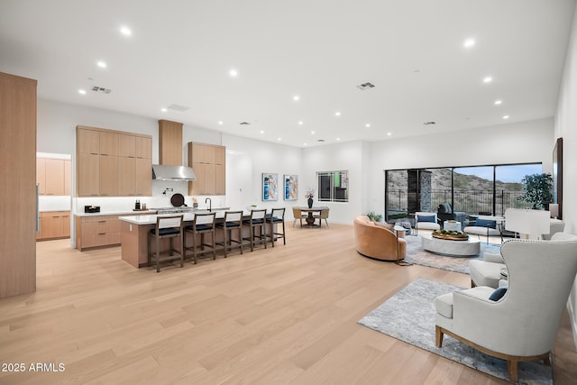 living area featuring light wood finished floors, recessed lighting, and visible vents