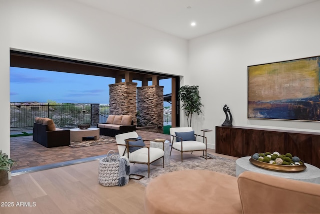 sitting room featuring a towering ceiling, wood finished floors, and recessed lighting