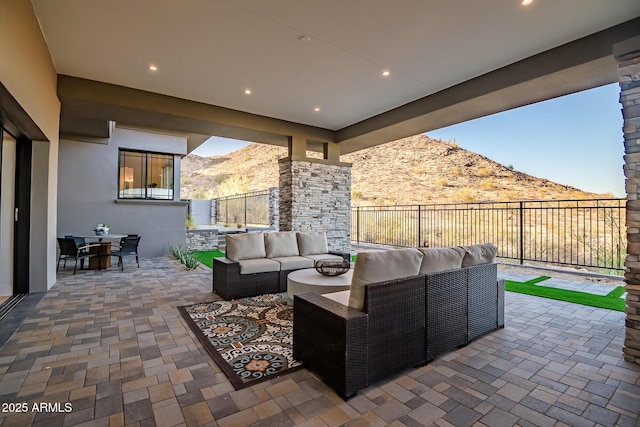 view of patio featuring a mountain view, an outdoor hangout area, outdoor dining area, and a fenced backyard