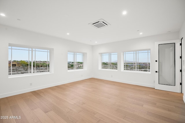 unfurnished room featuring baseboards, visible vents, light wood-type flooring, and recessed lighting