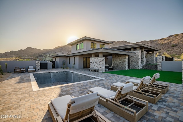 view of pool with a mountain view, fence, and a patio area