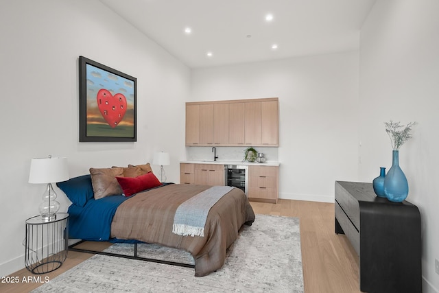 bedroom with recessed lighting, wine cooler, wet bar, light wood-style flooring, and baseboards