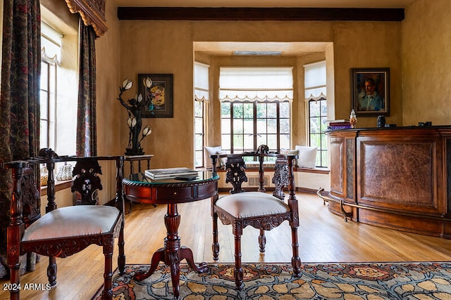 sitting room featuring beamed ceiling and light wood-type flooring