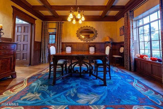 dining room with light hardwood / wood-style floors, a notable chandelier, beam ceiling, and coffered ceiling