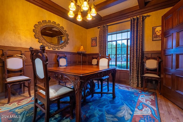 dining area featuring crown molding, wood-type flooring, beam ceiling, and a chandelier