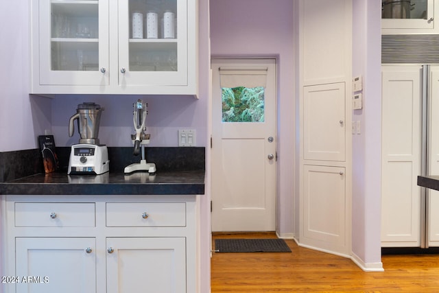 bar featuring light hardwood / wood-style flooring and white cabinetry