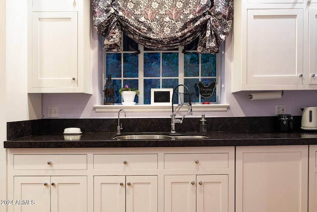 kitchen featuring white cabinetry and sink