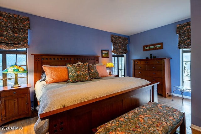 bedroom with light hardwood / wood-style floors and multiple windows